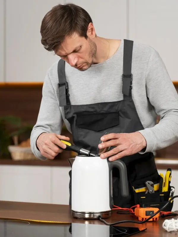 A local appliance technician repairing an electric kettle in a modern Jersey kitchen.