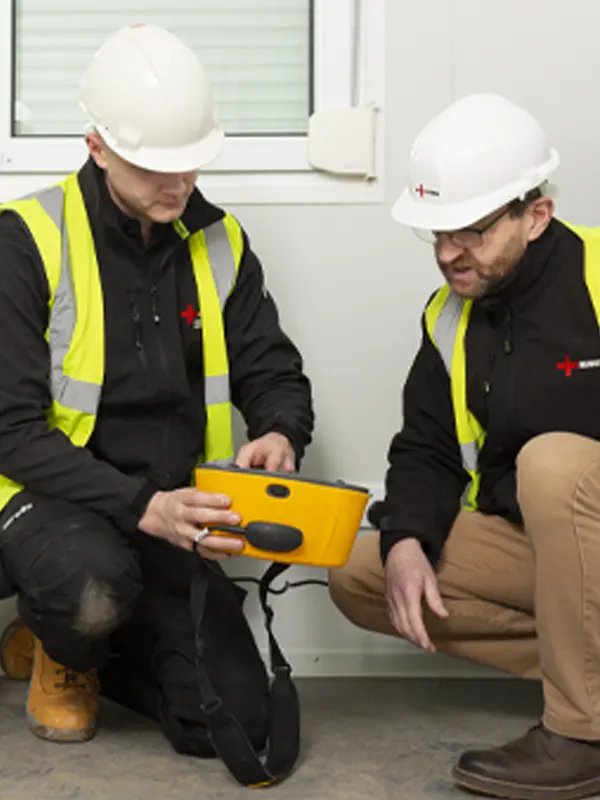 Two electricians in Jersey conducting an inspection, highlighting compliance with NICEIC-approved contractor standards.