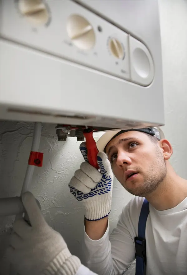 A Jersey heating engineer repairing a gas boiler for efficient home heating and hot water solutions.