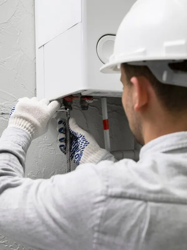 A local heating technician performing a boiler installation in Jersey to ensure efficient home heating and hot water supply.