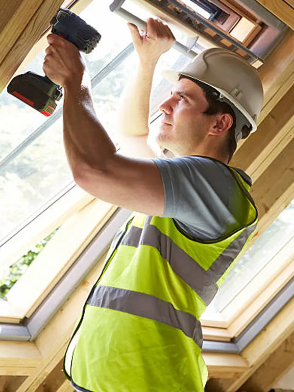 A local window carpenter installing a window in a St. Helier home in Jersey.