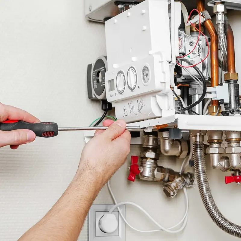 A local heating engineer performing an emergency boiler repair, fixing internal components to restore heating and hot water in Jersey,