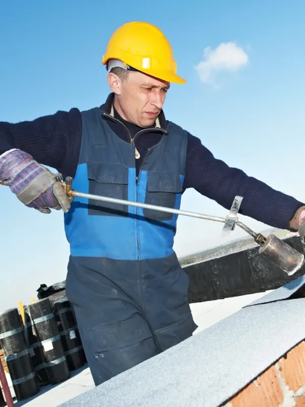 A flat roofer fixing a residential roof in Jersey.